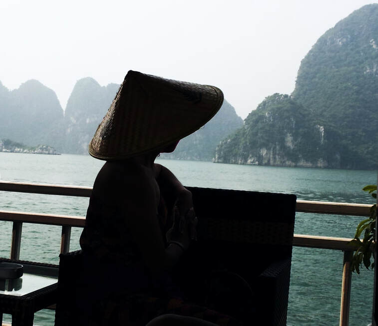 A woman gazes out at the Limestone rocks from a cruise boat in Halong Bay,Vietnam, Candid Photography