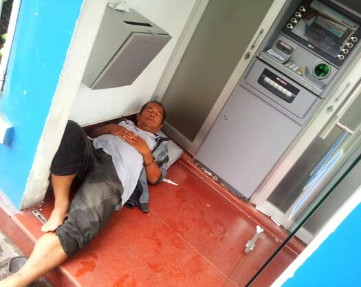 A guy sleeping in an ATM booth on the streets in Saigon, HCM city. Candid Photography