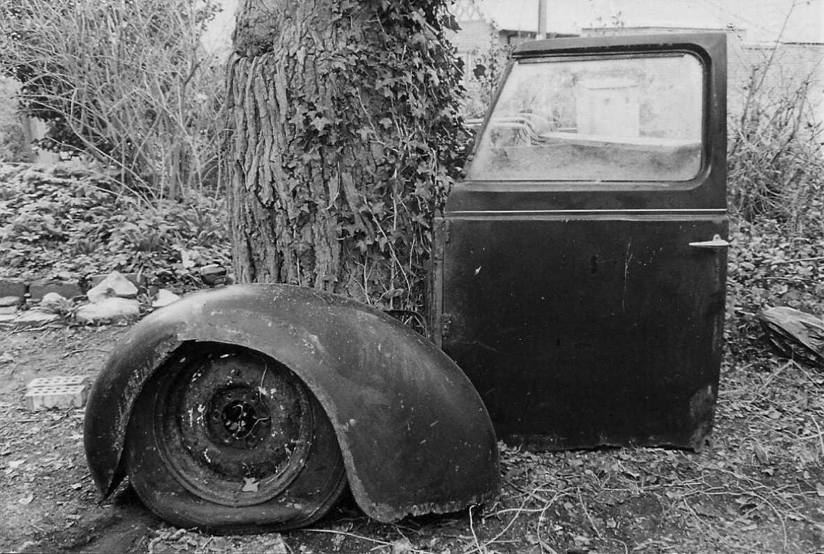 1951 Austin Taxi door, wheel and arch. abstract art. B&W film photography, PentaxP30