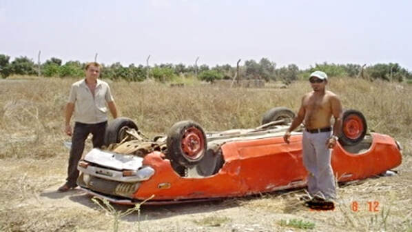 Two lads posing with an upturned car as if they have just been game hunting! Near Nicosia